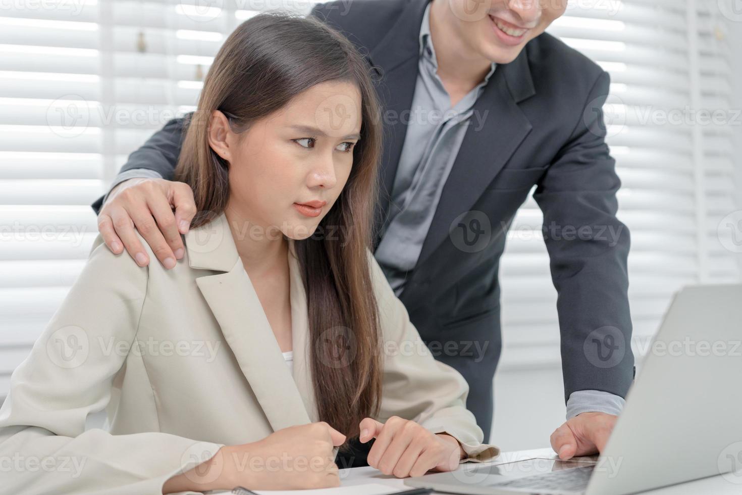 businessman sexually harassed a female colleague by touch her shoulder. Sexual harassment in office. Women feel anxious and stressed from being harassed. molest, assault, inappropriate, discrimination photo