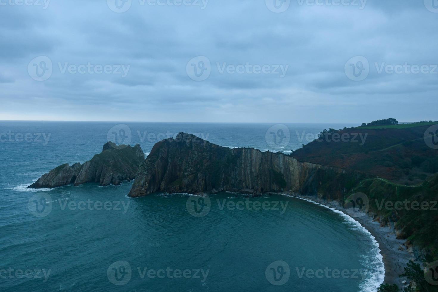 silencio playa, arena plateada ensenada Respaldados por un natural rock anfiteatro en Asturias, España. foto