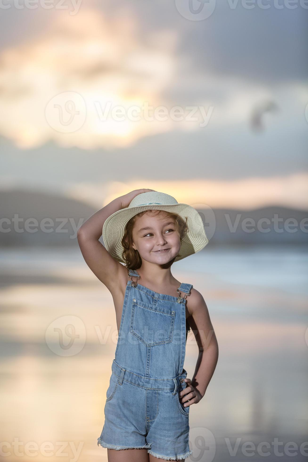 Girl touching hat on beach 19986976 Stock Photo at Vecteezy