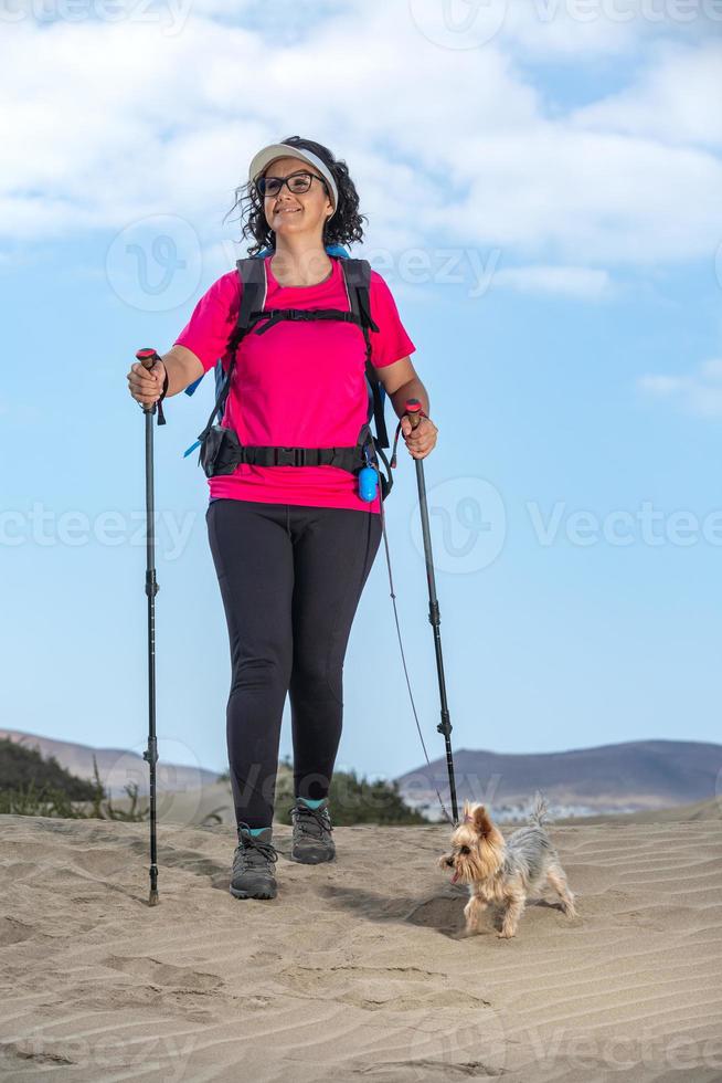 Traveling woman with dog on sandy beach photo