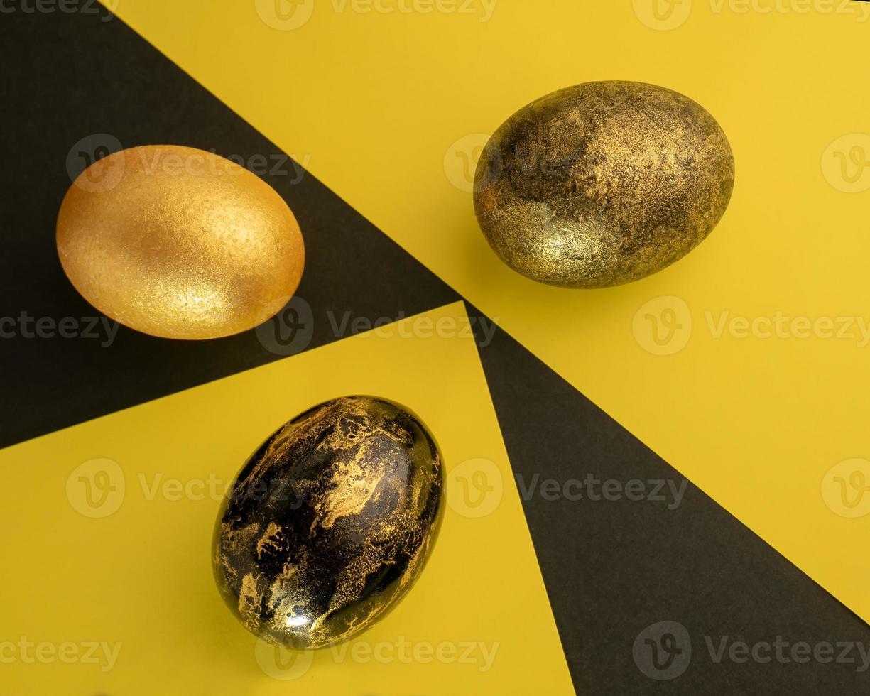 Bright Easter. Eggs are black and gold on the background of a geometric pattern. photo