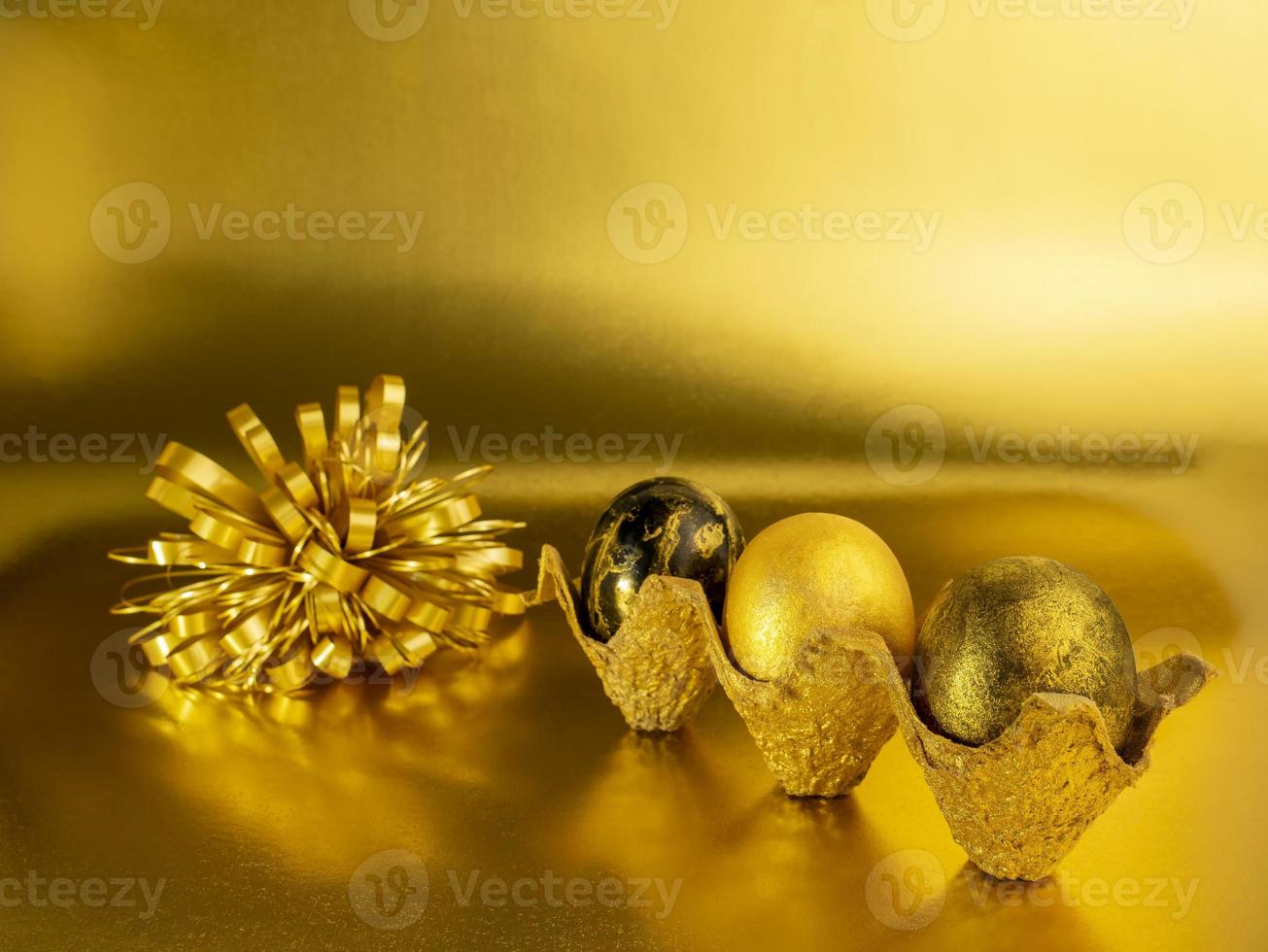 Stylish concept of Easter golden eggs. Easter golden eggs on a golden background. Postcard with copy space photo