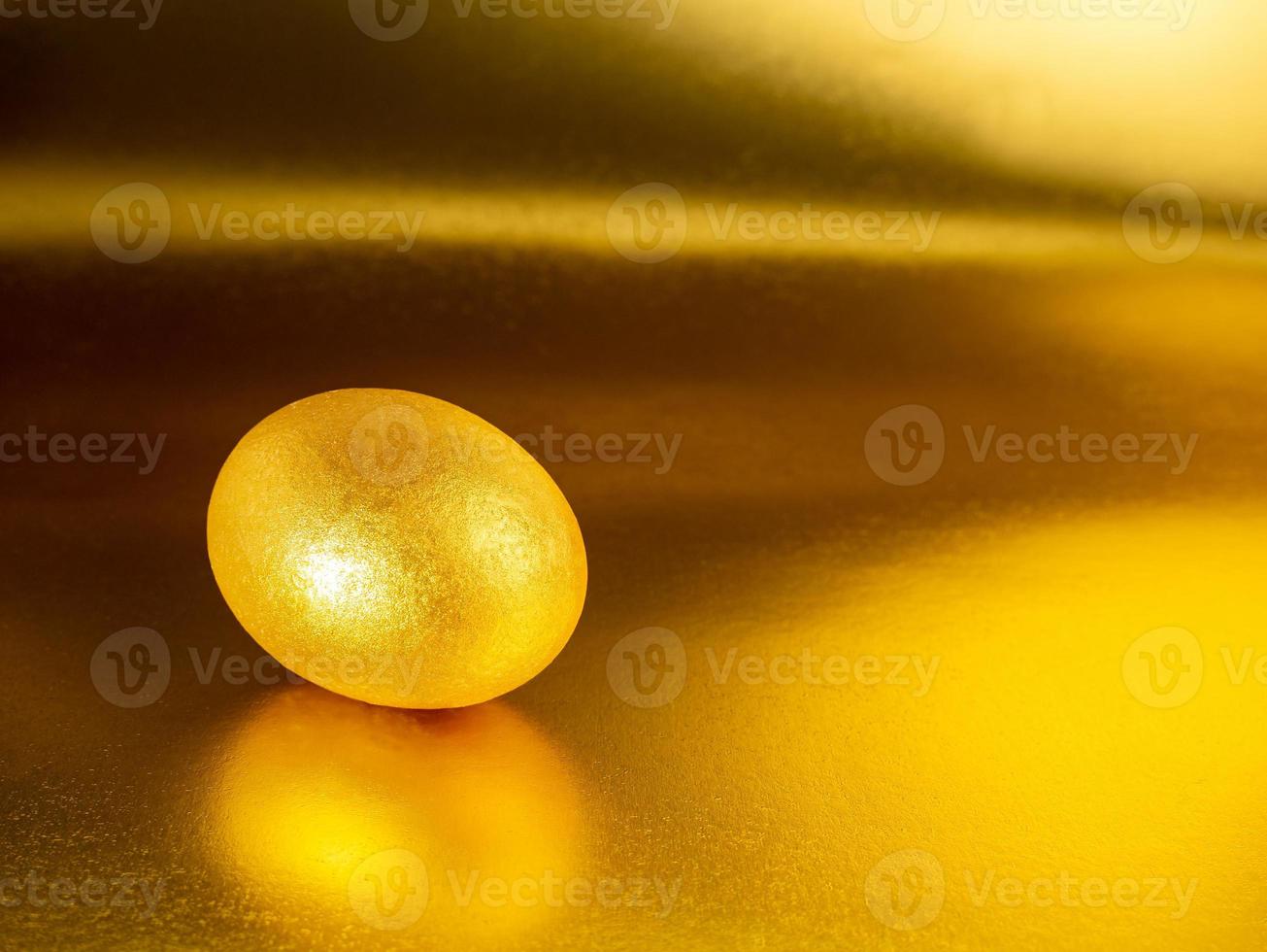 Golden egg on a Golden, glittering background for the holiday of bright Easter photo