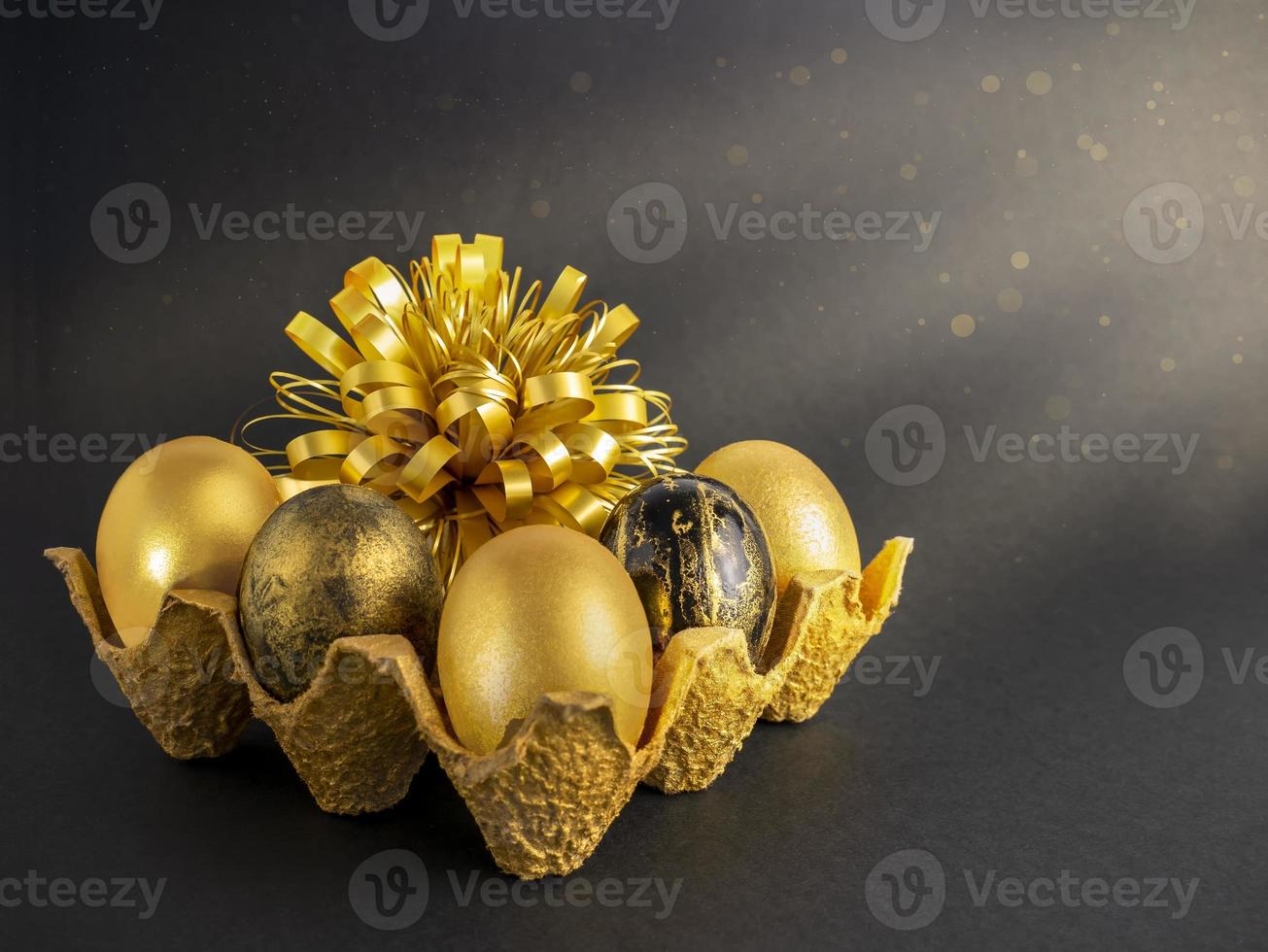 Stylish concept of Easter golden eggs. Easter golden eggs on a dark background with bokeh. Postcard with copy space photo