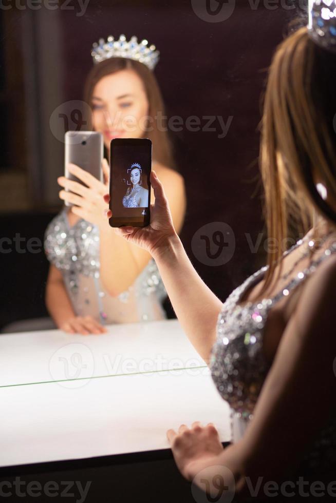 Reflection lovely young woman making selfie photo