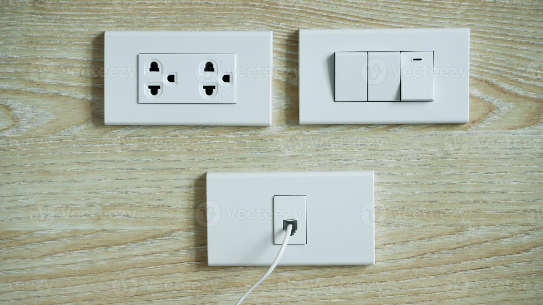 Electrical switch and plug on wooden wall,AC power plugs and sockets,White Plugs socket and Cable TV outlet receptacle on wall. photo