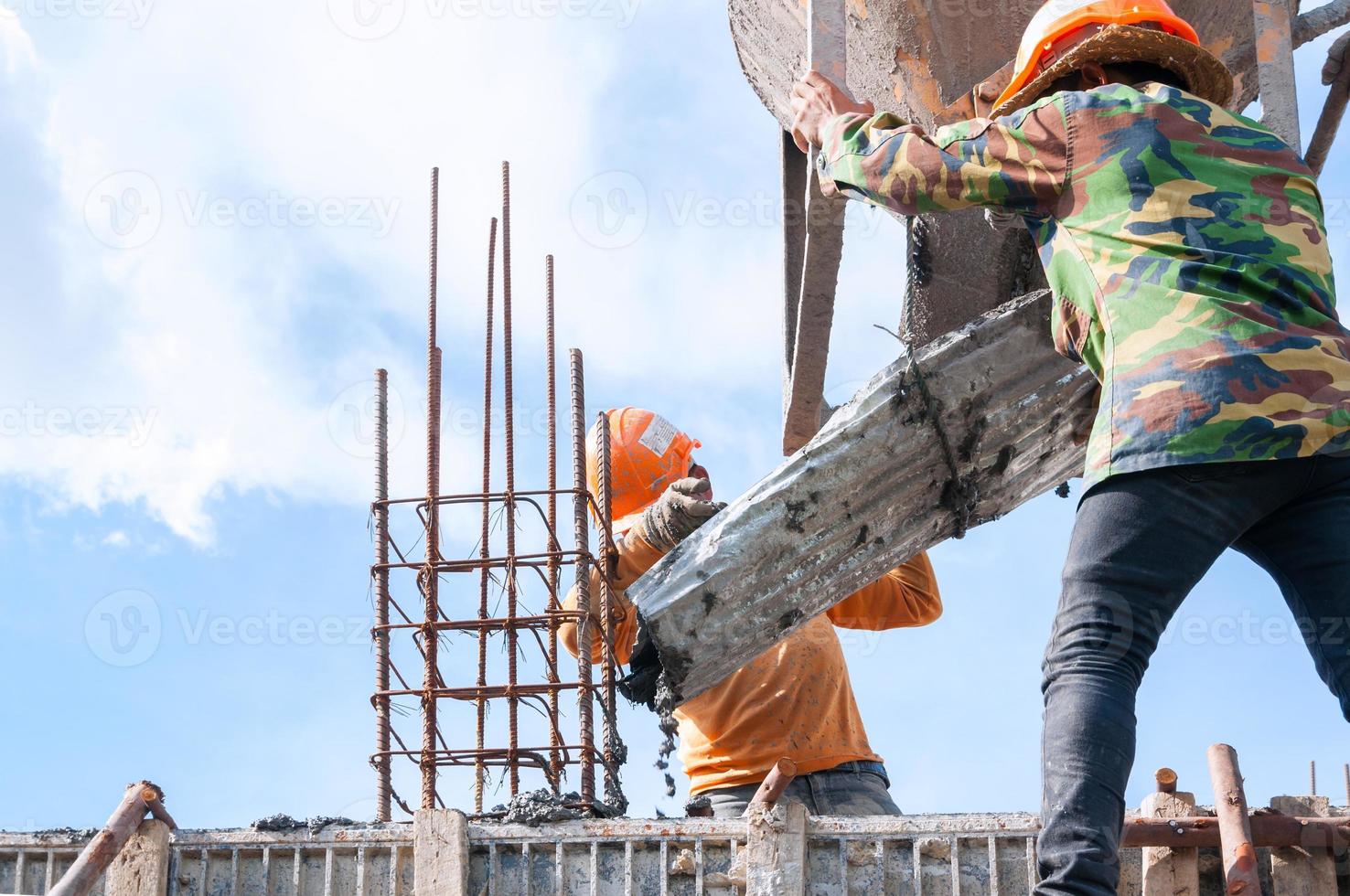 Construction building workers at construction site pouring concrete in form,Man Working at height with blue sky at construction site photo