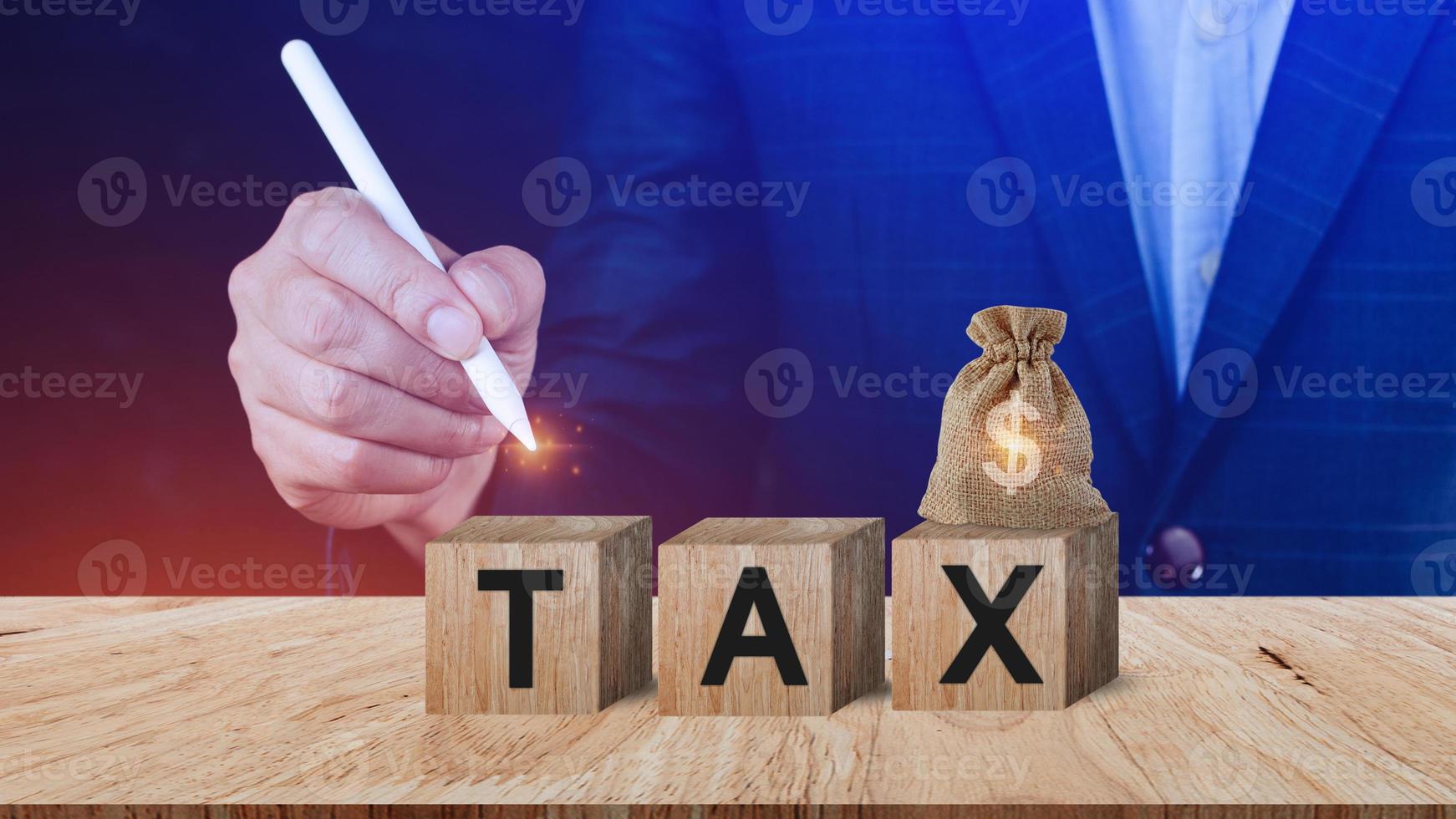 Businessman choose wooden blocks with the word Tax. Concept of reducing the tax burden. Tax avoidance. Costs and expenses of the business. Taxation. Pay off debt. Freedom from illegal taxes photo