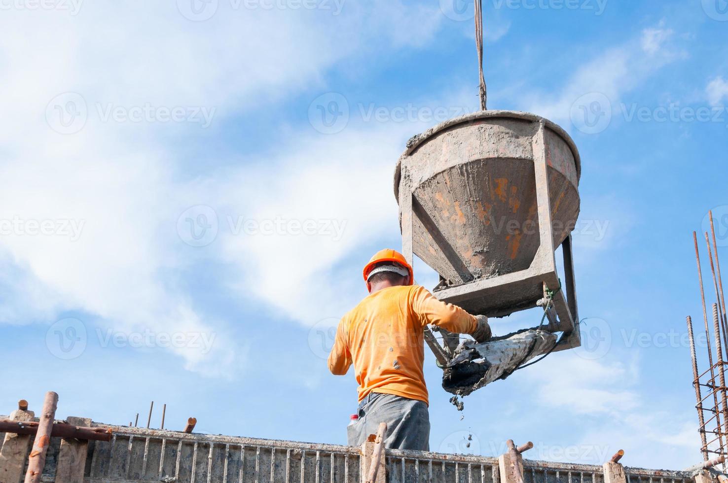 Construction building workers at construction site pouring concrete in form,Man Working at height with blue sky at construction site photo