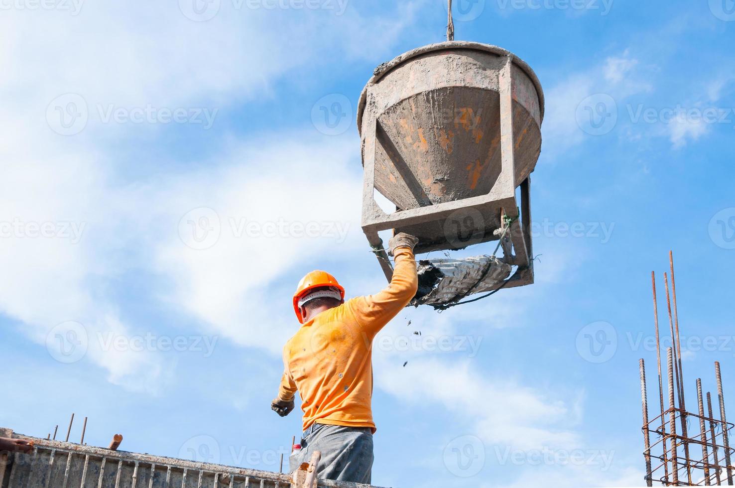 Construction building workers at construction site pouring concrete in form,Man Working at height with blue sky at construction site photo