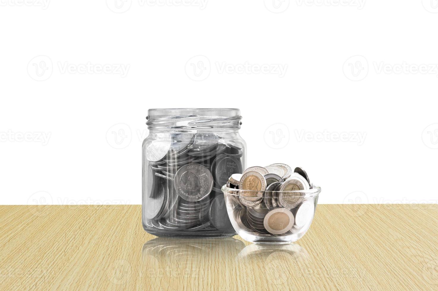 coins in a glass jar on Wood floor ,savings coins - Investment And Interest Concept saving money concept, growing money on piggy bank. isolated on white background photo