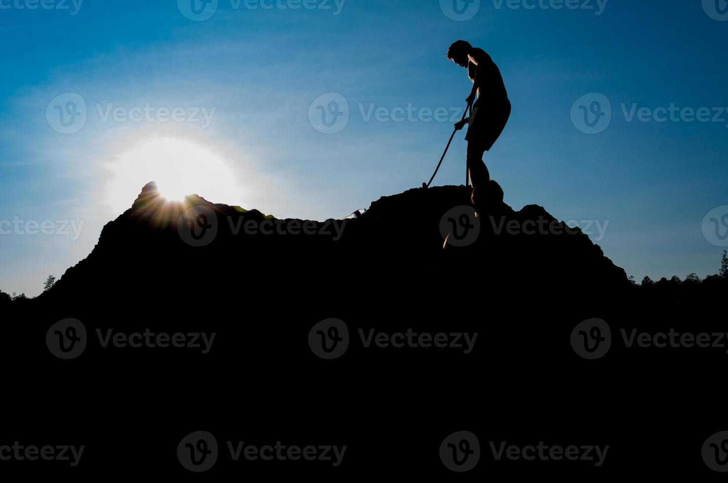 Climber on sunset sky background photo