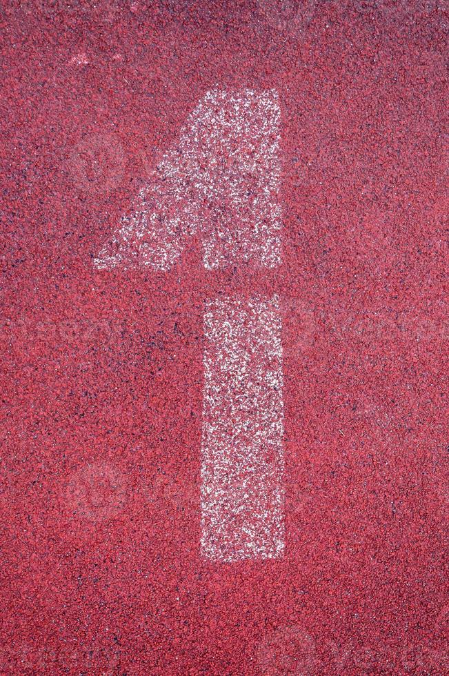 número uno en corriendo pista. blanco pista número en rojo caucho pista, textura de corriendo pistas de carreras en estadio foto