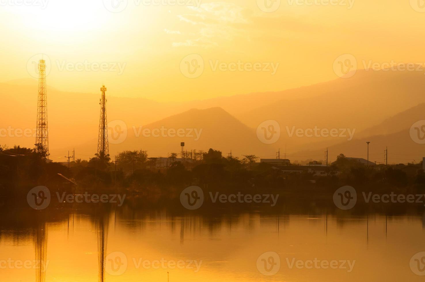 puesta de sol en el lago en brumoso con electricidad líneas en antecedentes foto