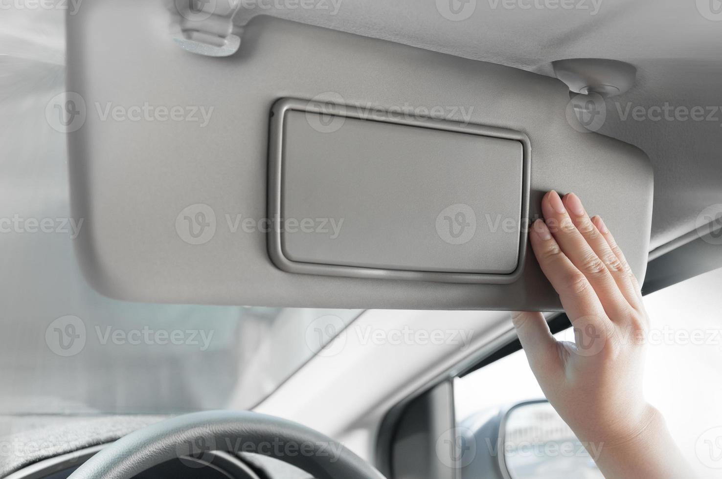 woman hand holding sun visor interior inside car photo