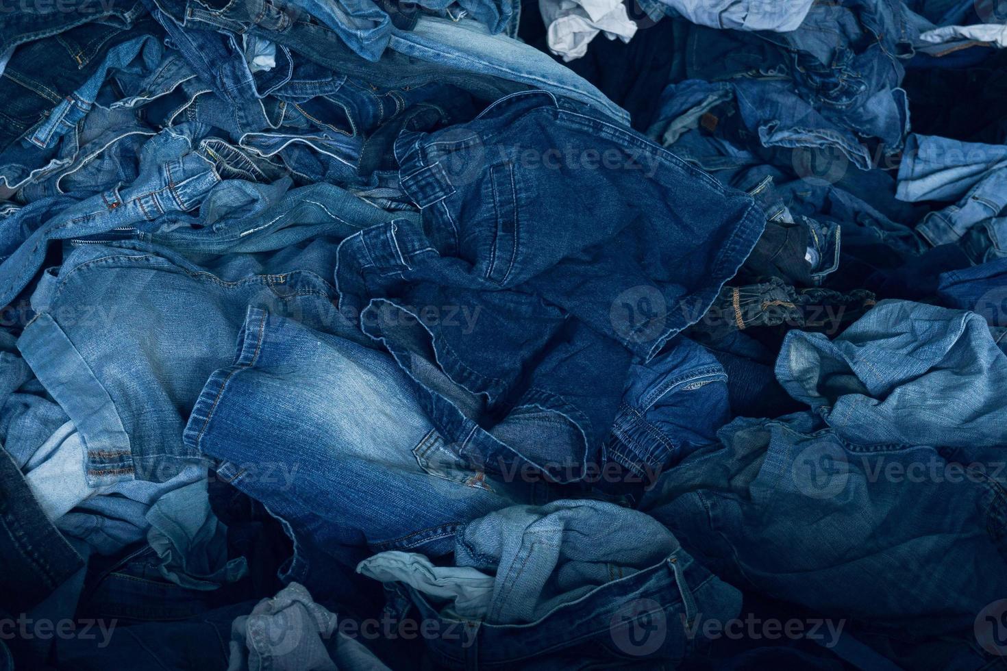 Stack of various shades blue jeans. Pile Blue denim jeans texture banner. Canvas denim fashion texture photo