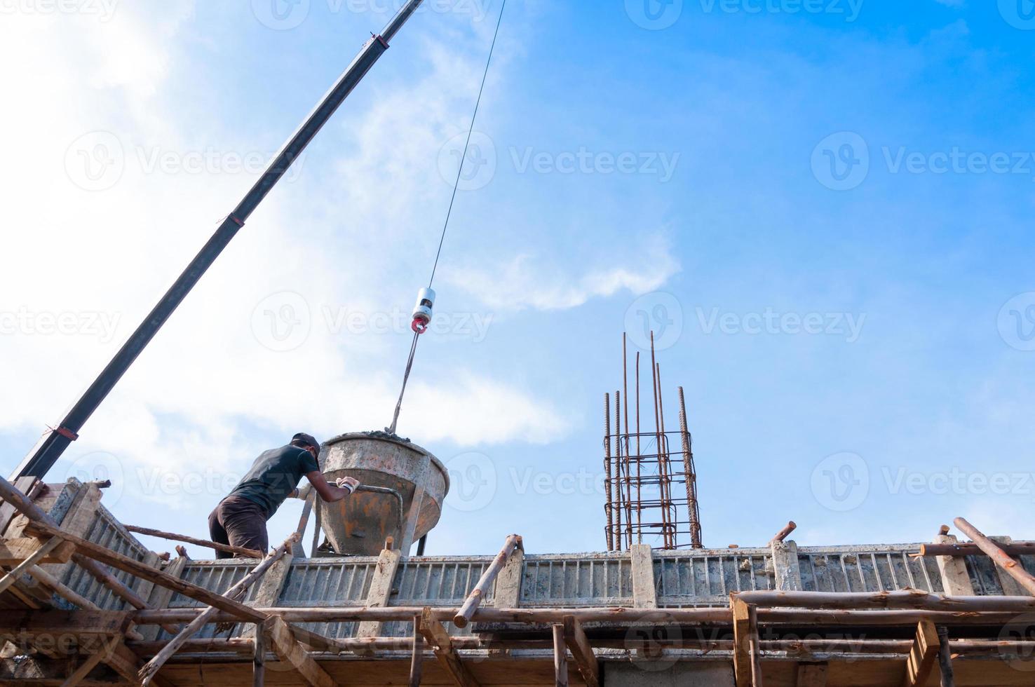 Construction building workers at construction site pouring concrete in form,Man Working at height with blue sky at construction site photo