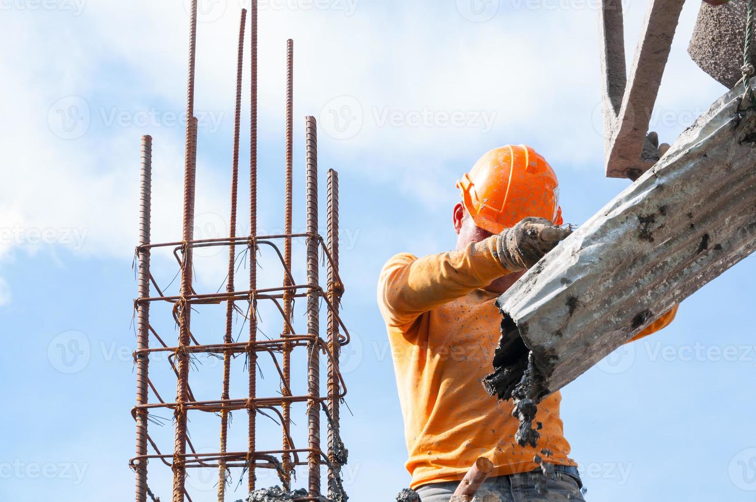 Construction building workers at construction site pouring concrete in form,Man Working at height with blue sky at construction site photo