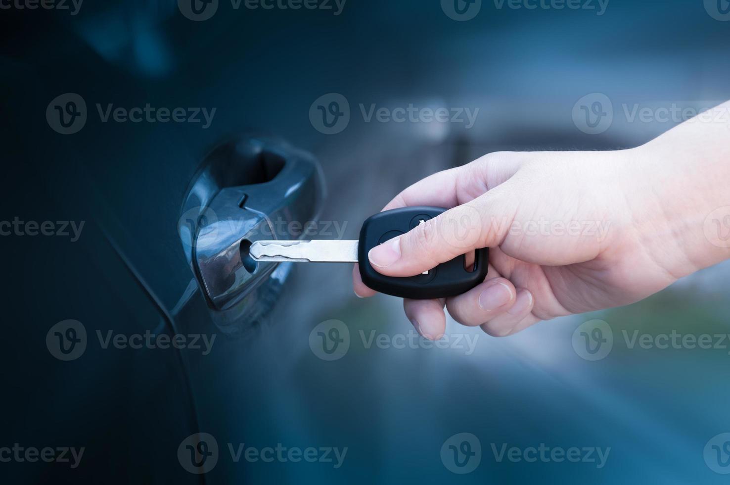 opening unlocking door with car key. Car keys closeup of hand holding key to lock or unlock doors photo