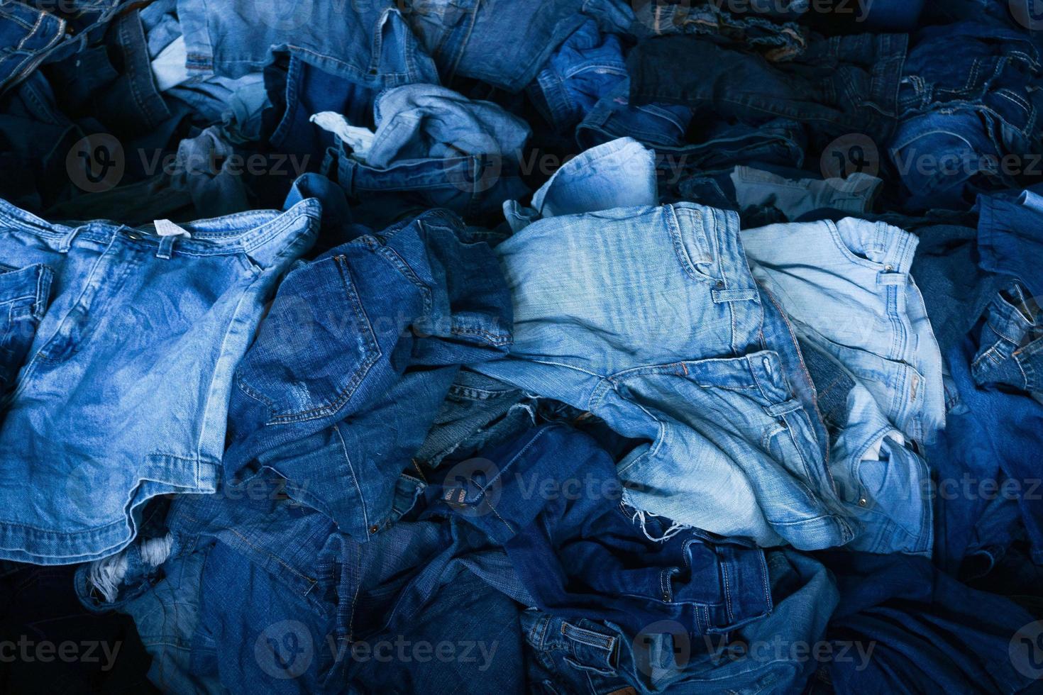 Stack of various shades blue jeans. Pile Blue denim jeans texture banner. Canvas denim fashion texture photo