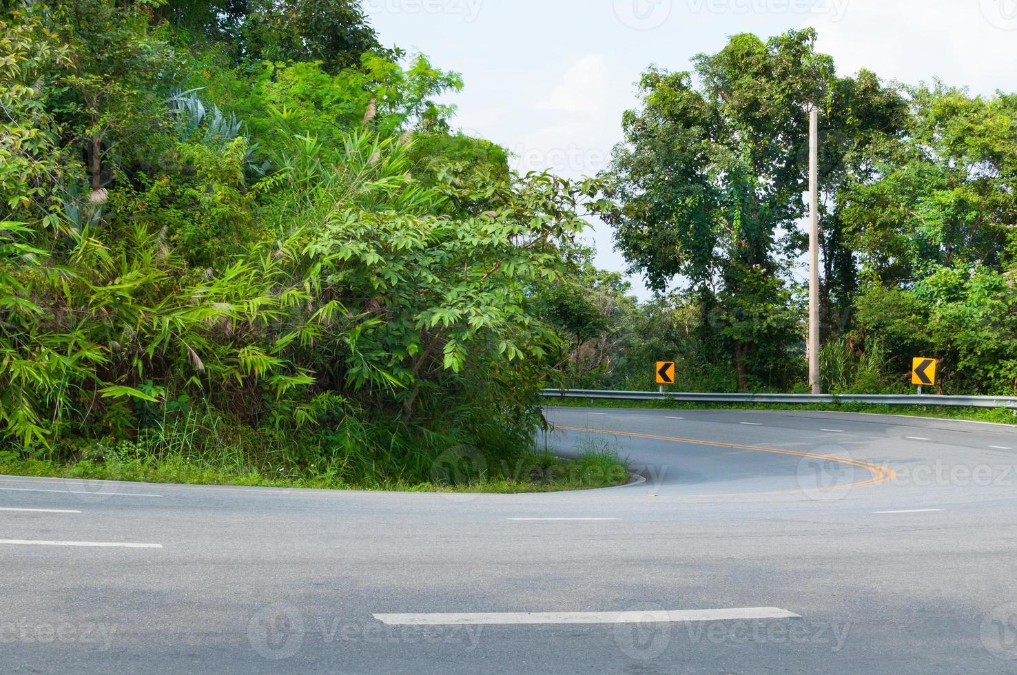 Countryside road with trees on both sides,Curve of the road to mountain photo