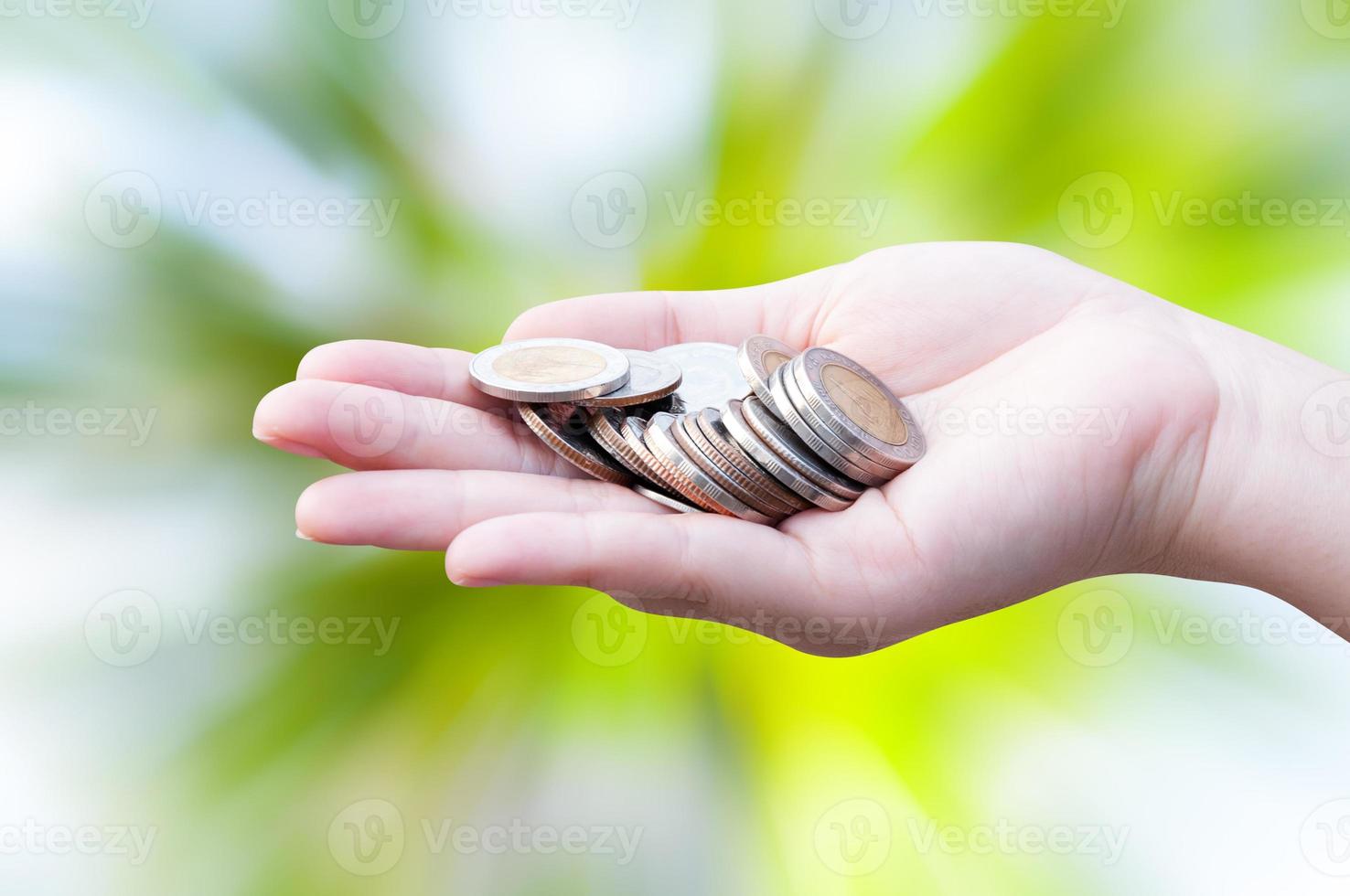 monedas en manos en verde naturaleza fondo donación inversión fondo financiero apoyo caridad dividendo mercado crecimiento foto