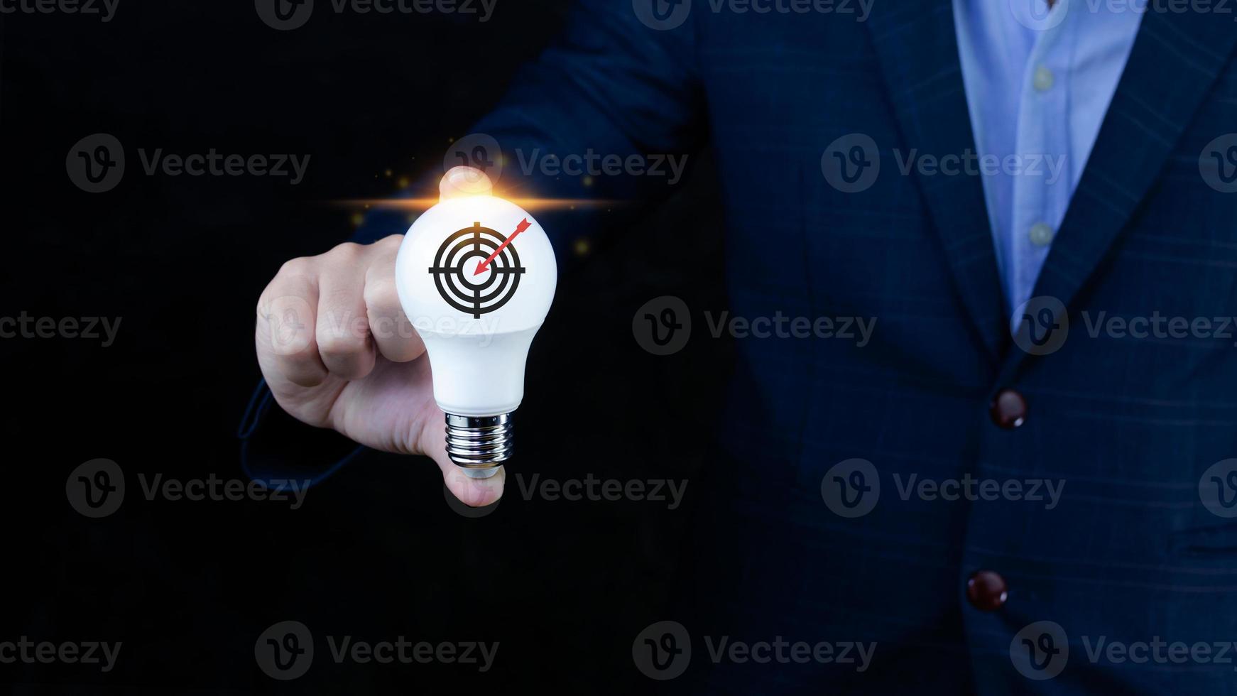 Businessman holding light bulb for concept new idea with virtual dartboard and arrow with copy space for setup business objective target concept. photo