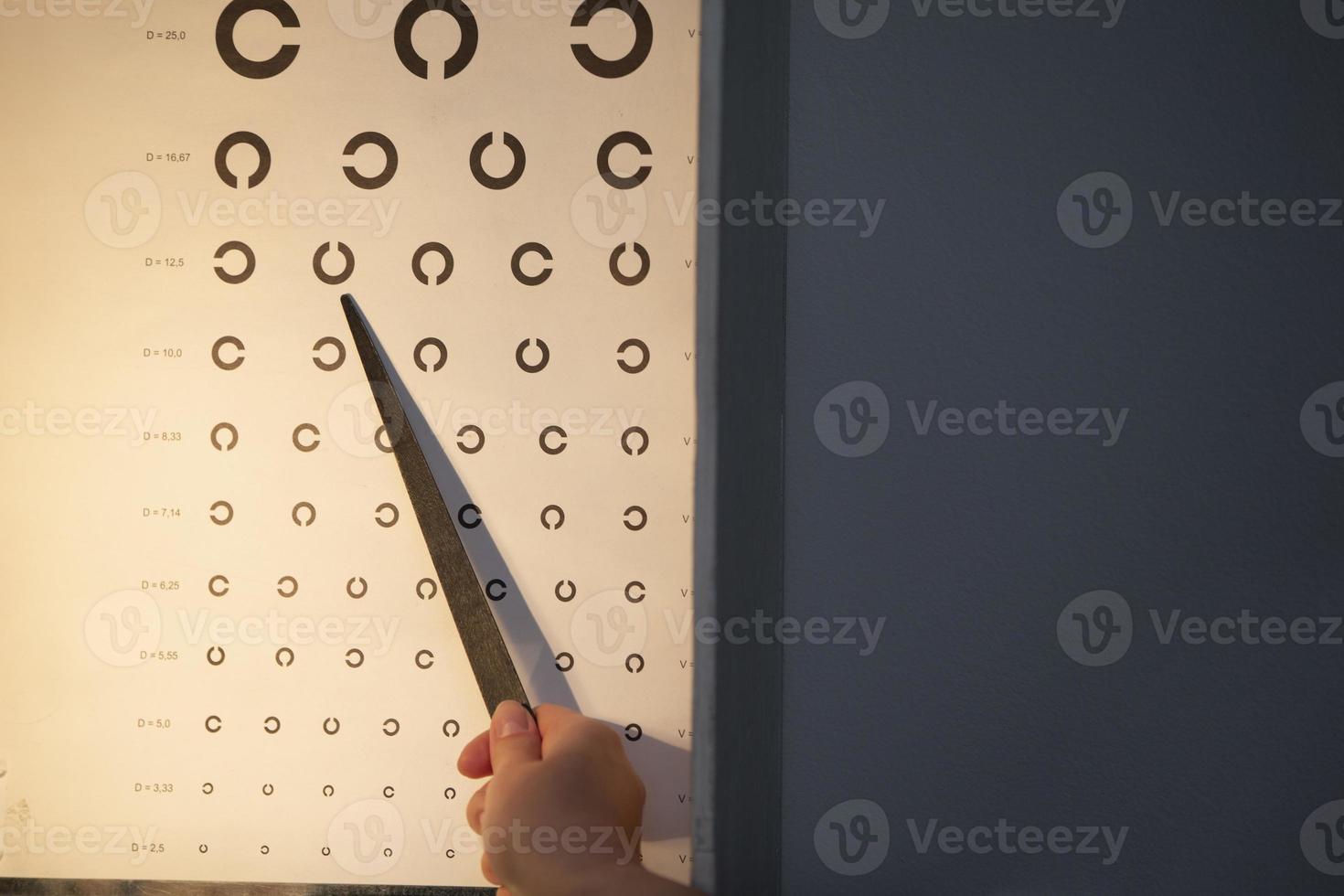A hand with a pointer, an eye chart that can be used to measure visual acuity. The concept of vision correction photo