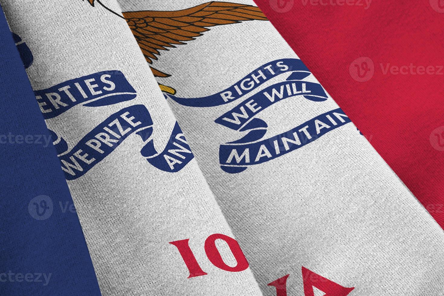 Iowa US state flag with big folds waving close up under the studio light indoors. The official symbols and colors in banner photo