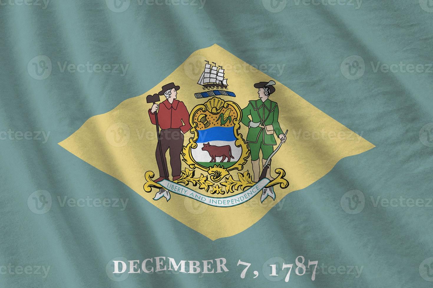 Delaware US state flag with big folds waving close up under the studio light indoors. The official symbols and colors in banner photo