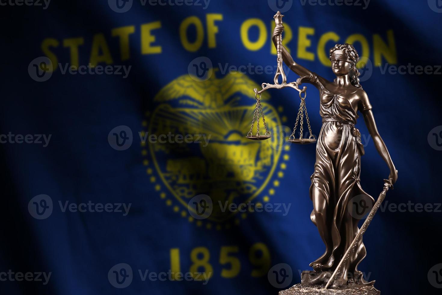 Oregon US state flag with statue of lady justice and judicial scales in dark room. Concept of judgement and punishment photo