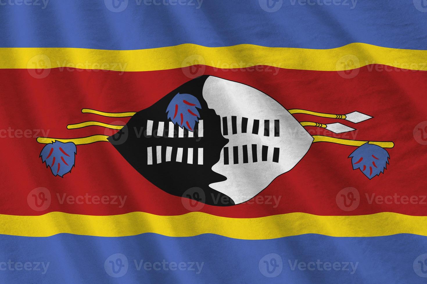 Swaziland flag with big folds waving close up under the studio light indoors. The official symbols and colors in banner photo