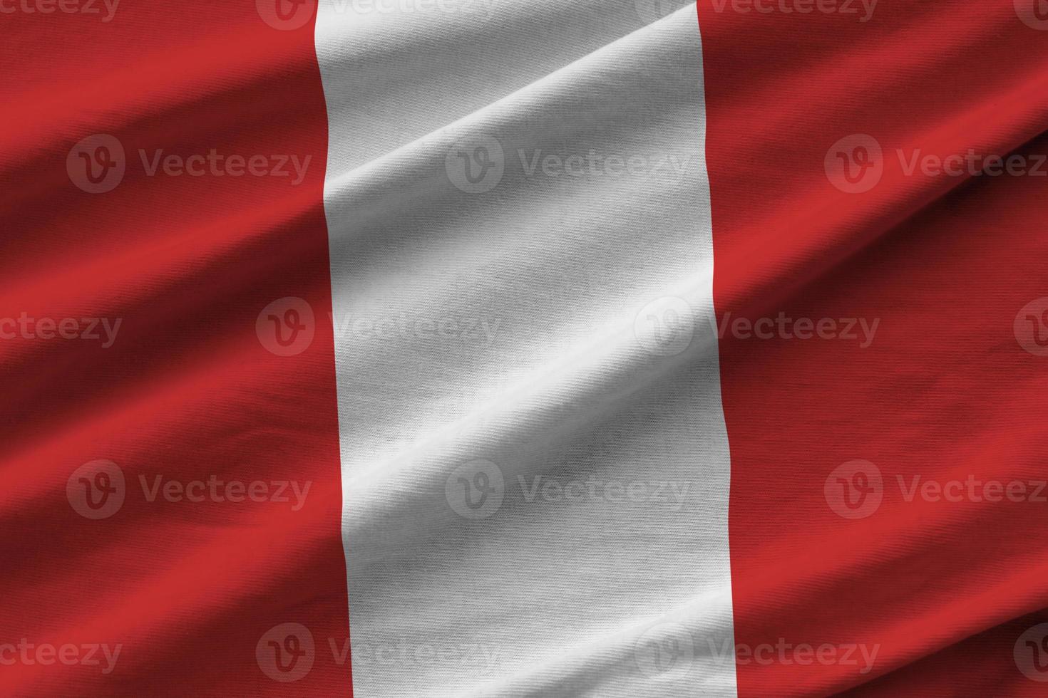 Peru flag with big folds waving close up under the studio light indoors. The official symbols and colors in banner photo