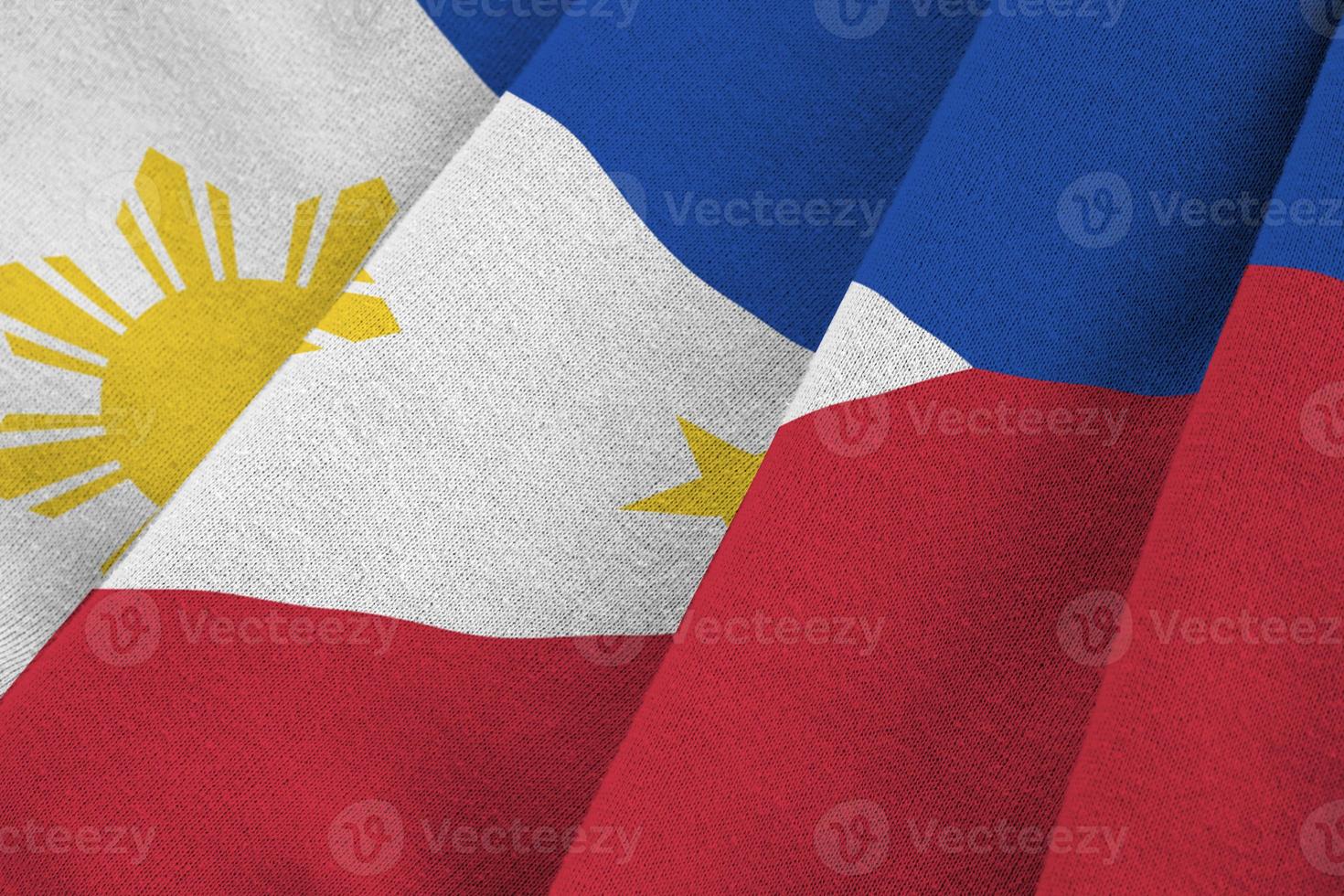 Philippines flag with big folds waving close up under the studio light indoors. The official symbols and colors in banner photo