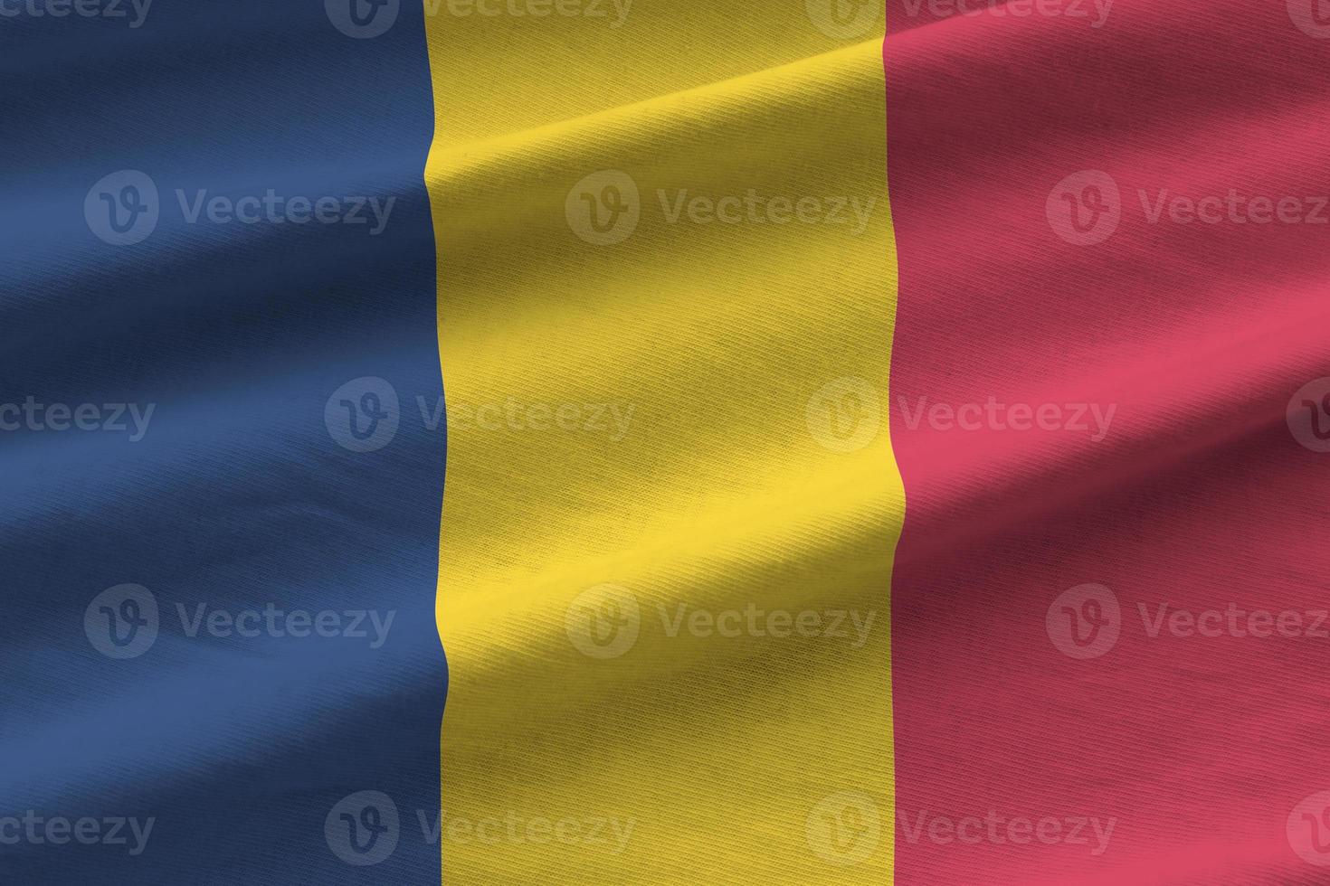 Chad flag with big folds waving close up under the studio light indoors. The official symbols and colors in banner photo