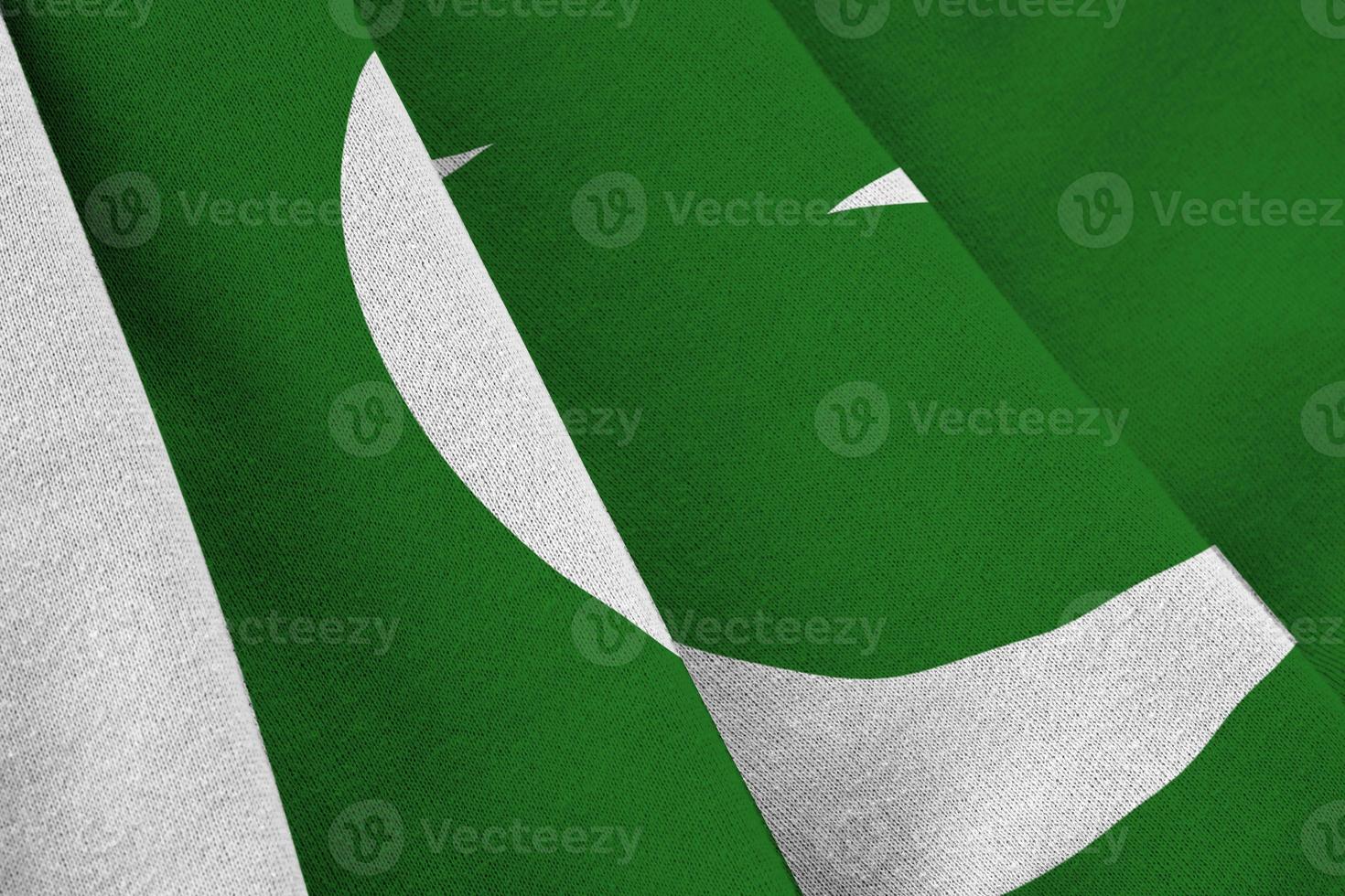 Pakistan flag with big folds waving close up under the studio light indoors. The official symbols and colors in banner photo