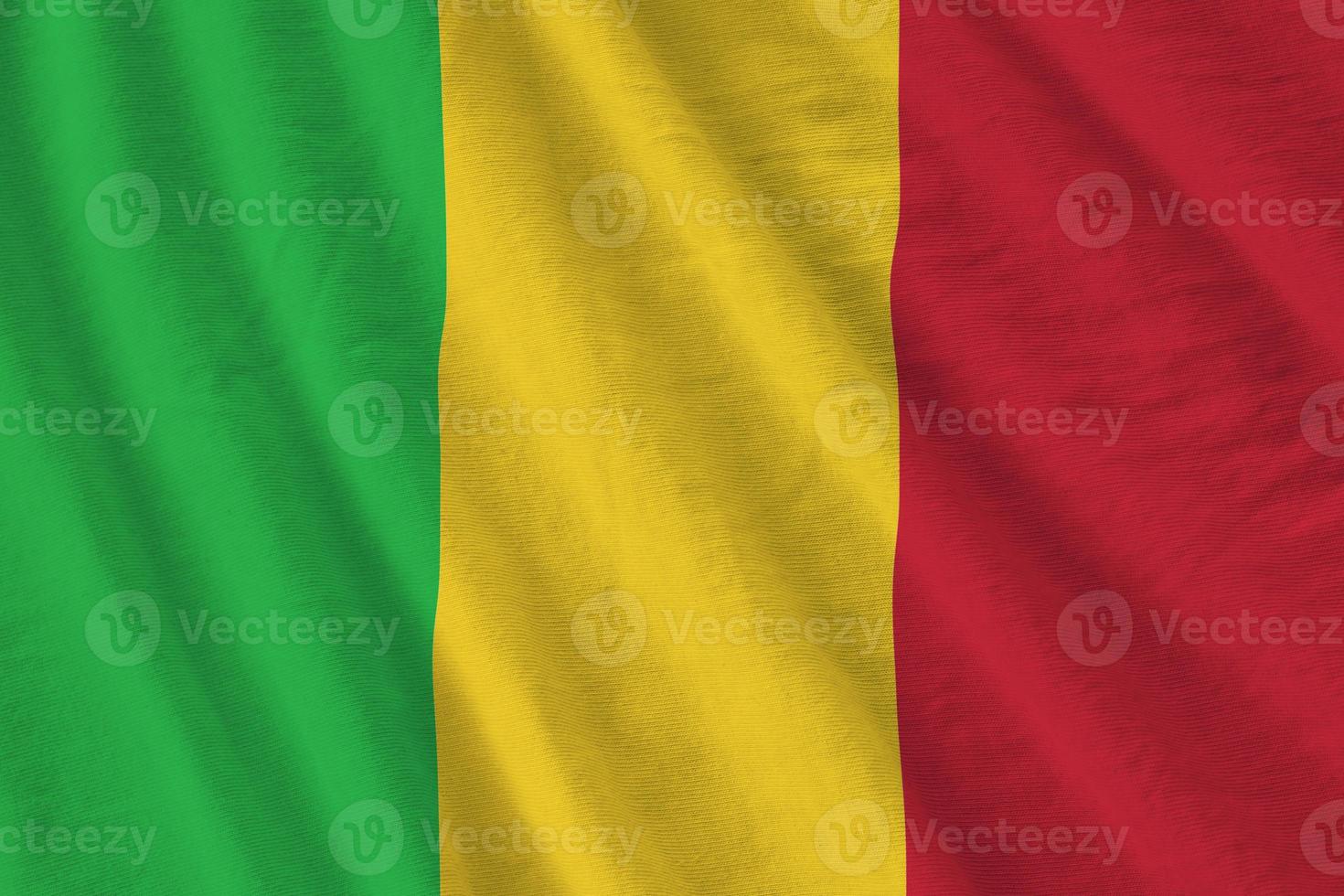 Mali flag with big folds waving close up under the studio light indoors. The official symbols and colors in banner photo