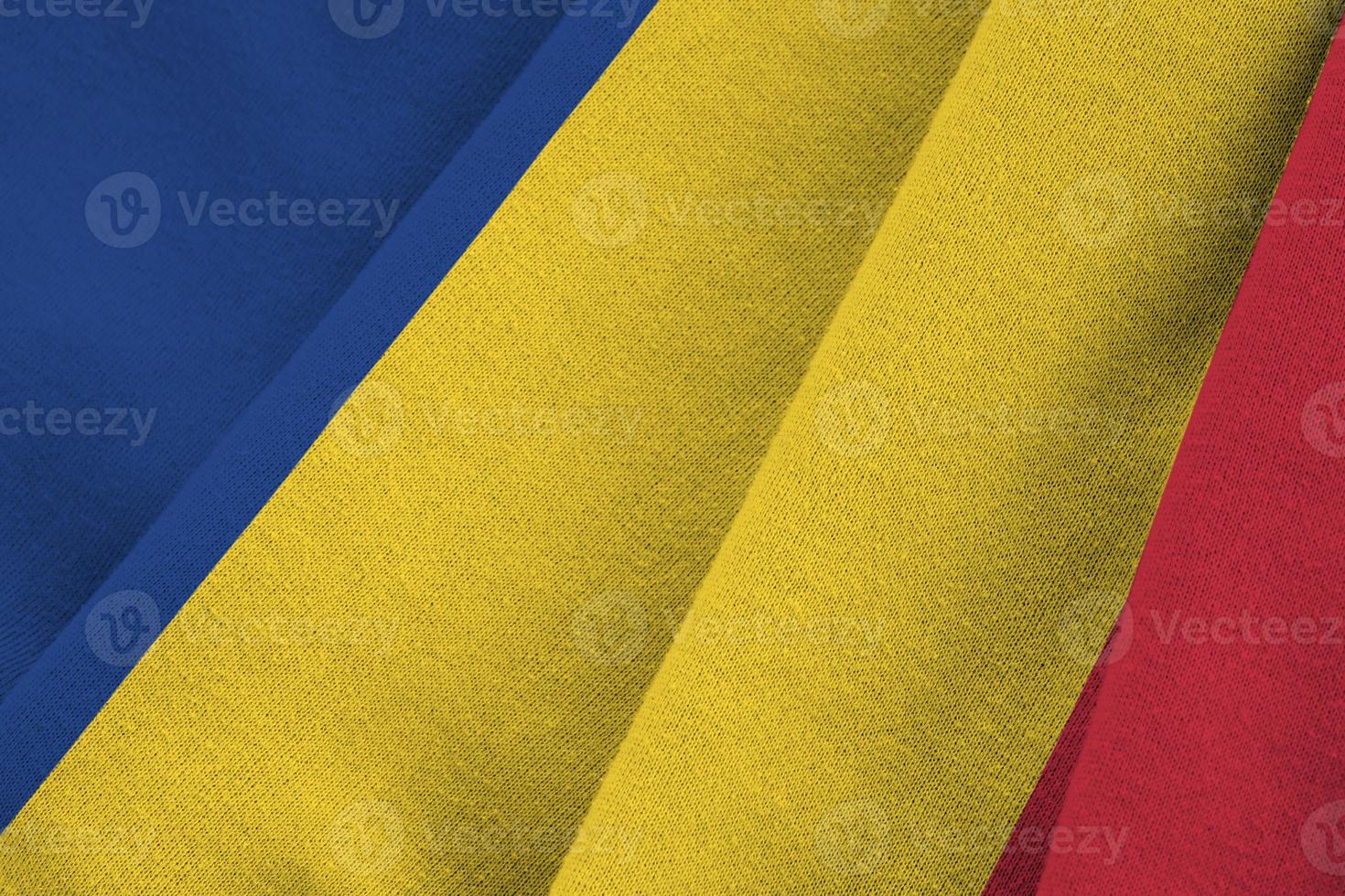 Romania flag with big folds waving close up under the studio light indoors. The official symbols and colors in banner photo