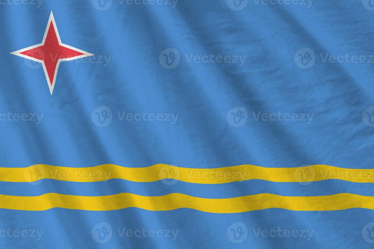 Aruba flag with big folds waving close up under the studio light indoors. The official symbols and colors in banner photo