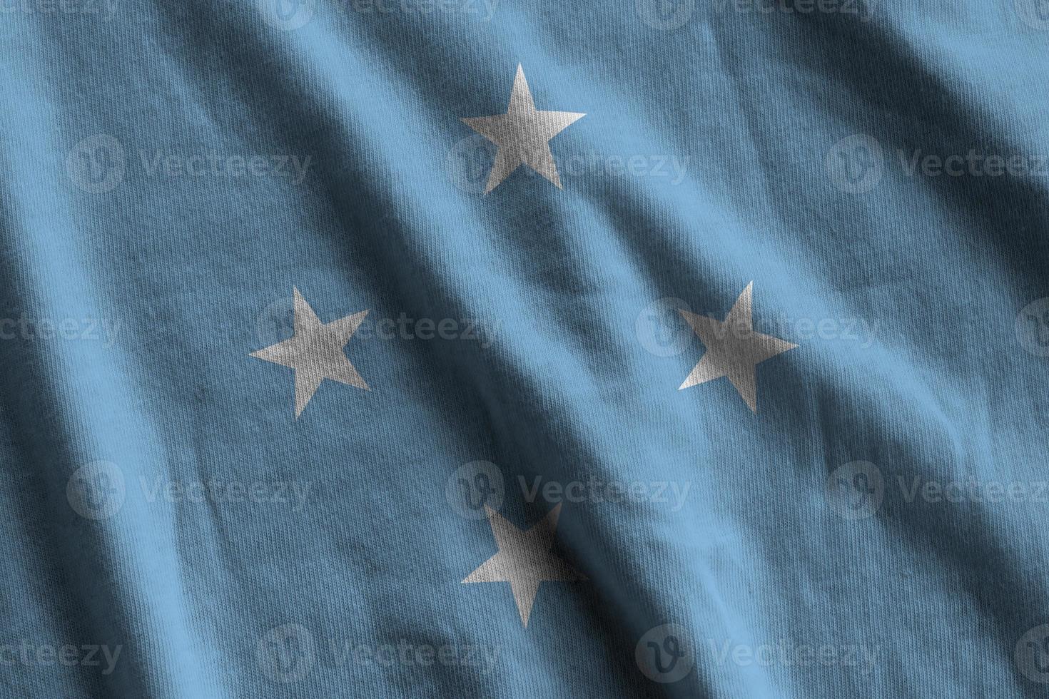 Micronesia flag with big folds waving close up under the studio light indoors. The official symbols and colors in banner photo