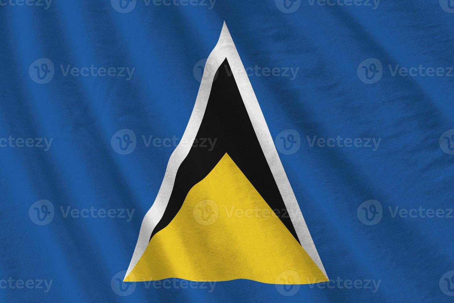 Saint Lucia flag with big folds waving close up under the studio light indoors. The official symbols and colors in banner photo