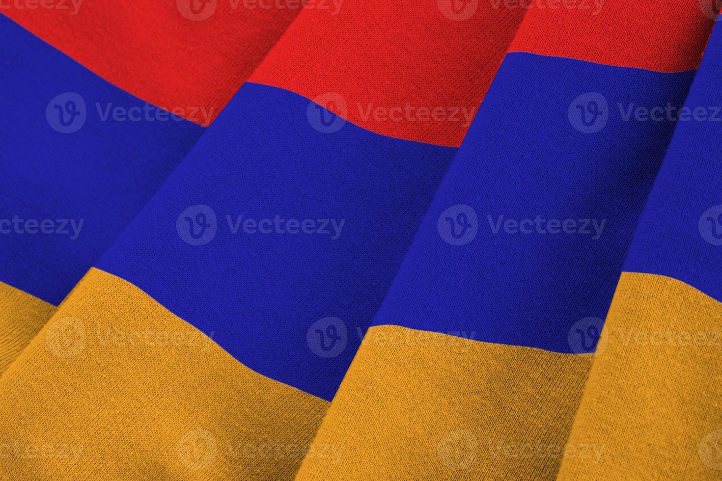 Armenia flag with big folds waving close up under the studio light indoors. The official symbols and colors in banner photo