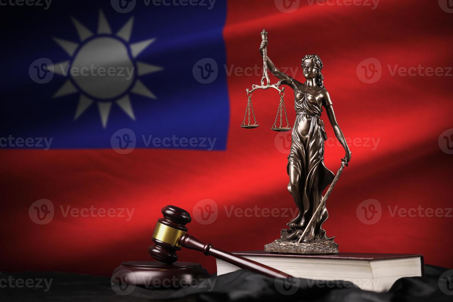 Taiwan flag with statue of lady justice, constitution and judge hammer on black drapery. Concept of judgement and guilt photo