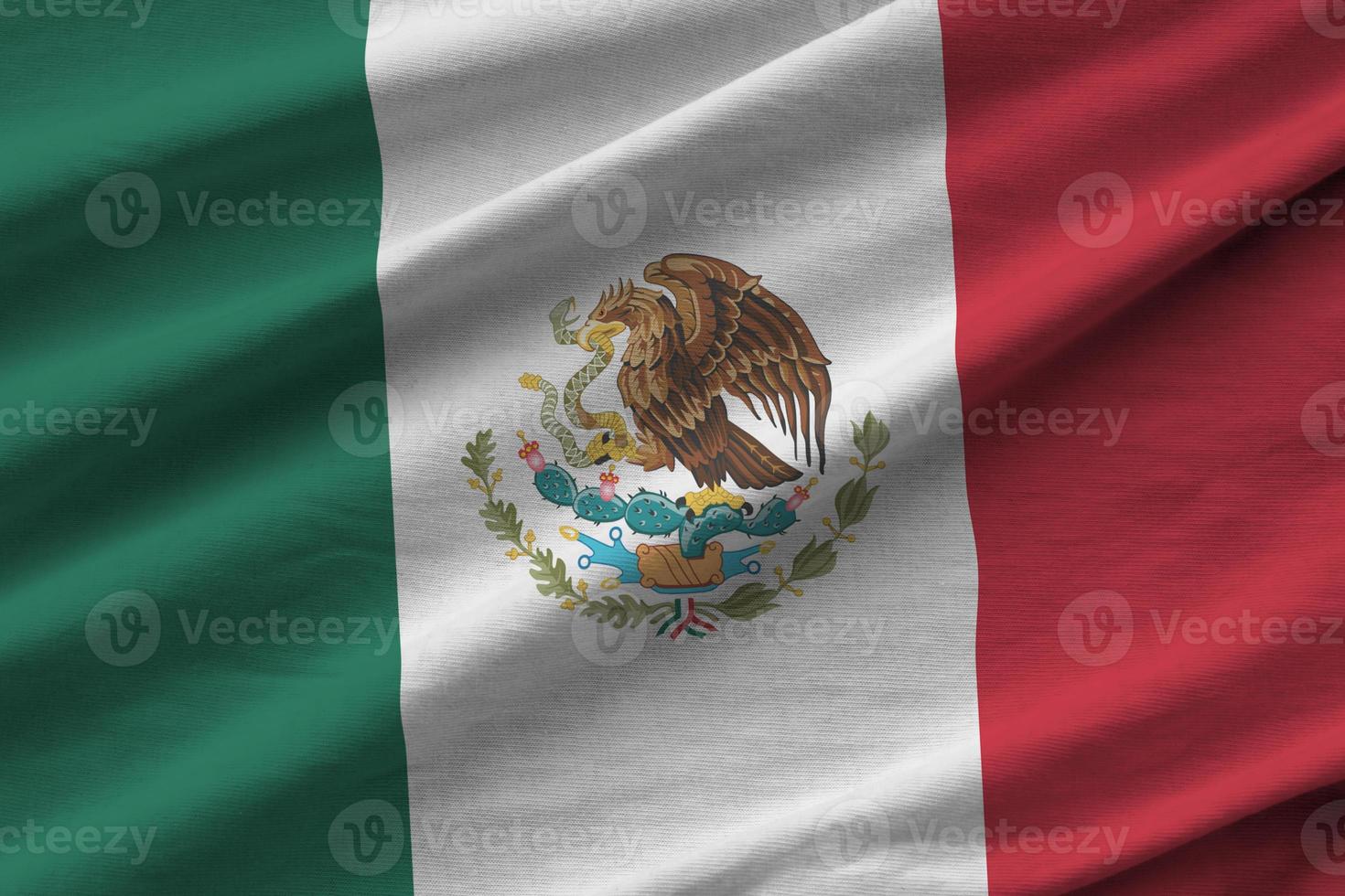 Mexico flag with big folds waving close up under the studio light indoors. The official symbols and colors in banner photo