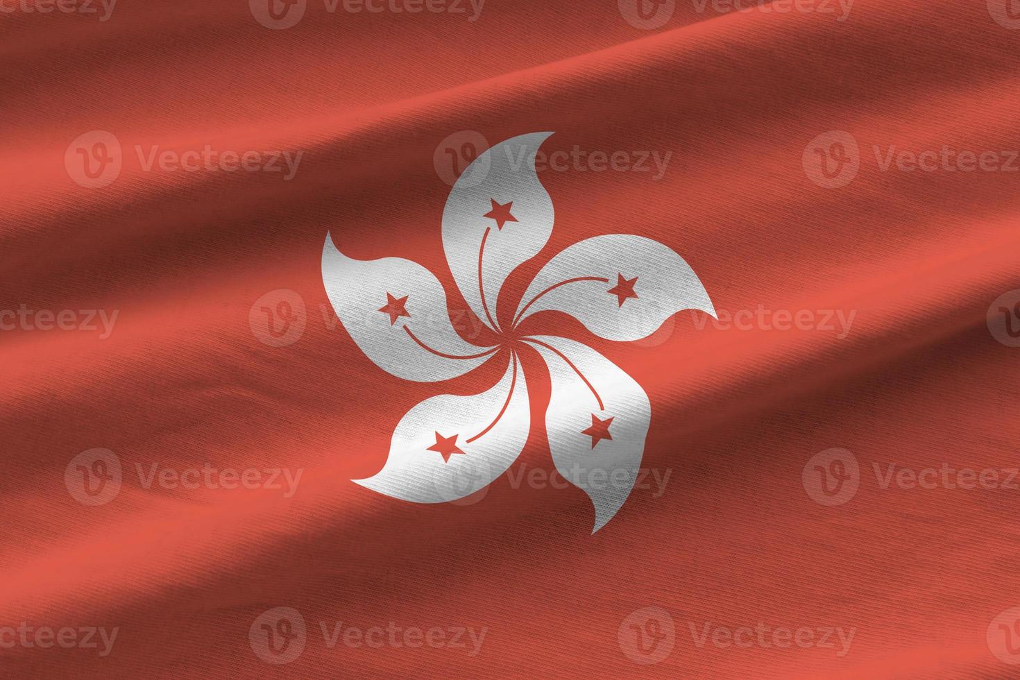 Hong kong flag with big folds waving close up under the studio light indoors. The official symbols and colors in banner photo