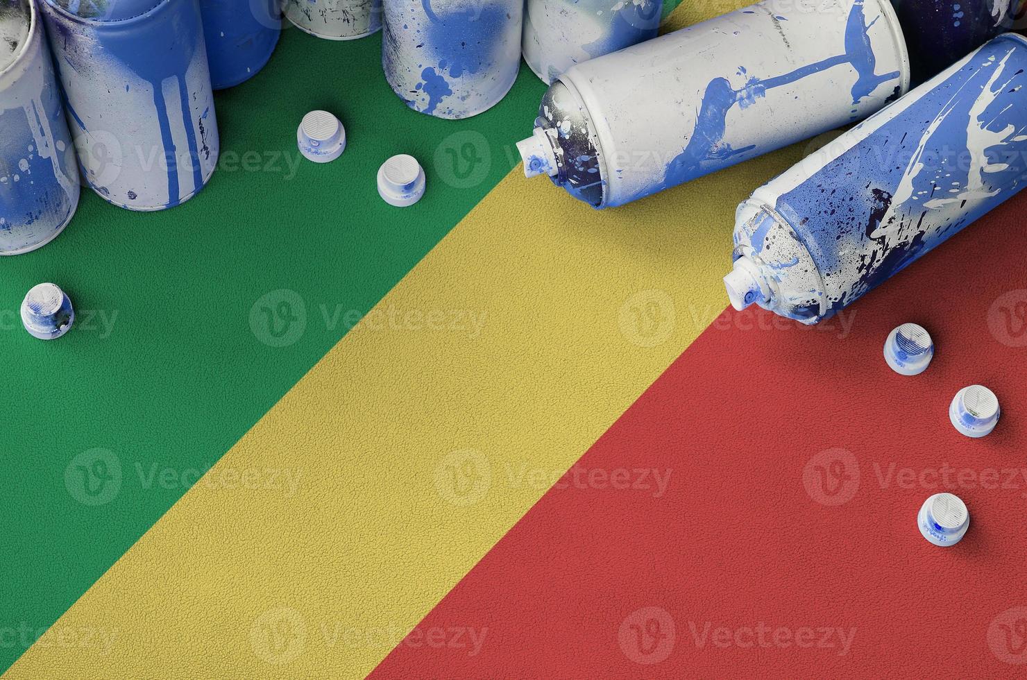 Congo flag and few used aerosol spray cans for graffiti painting. Street art culture concept photo