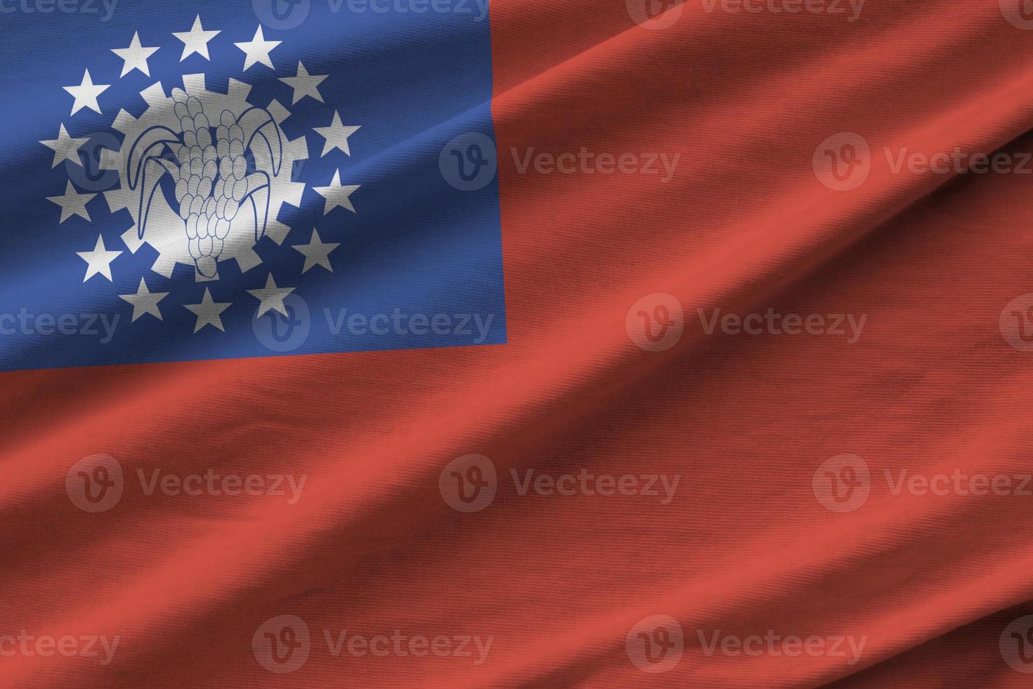 Myanmar flag with big folds waving close up under the studio light indoors. The official symbols and colors in banner photo