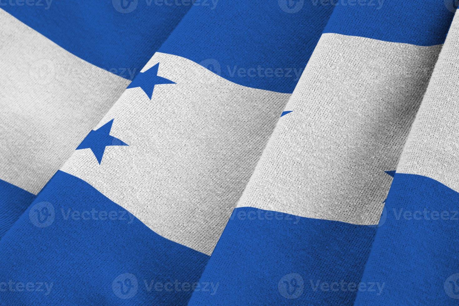 Honduras flag with big folds waving close up under the studio light indoors. The official symbols and colors in banner photo