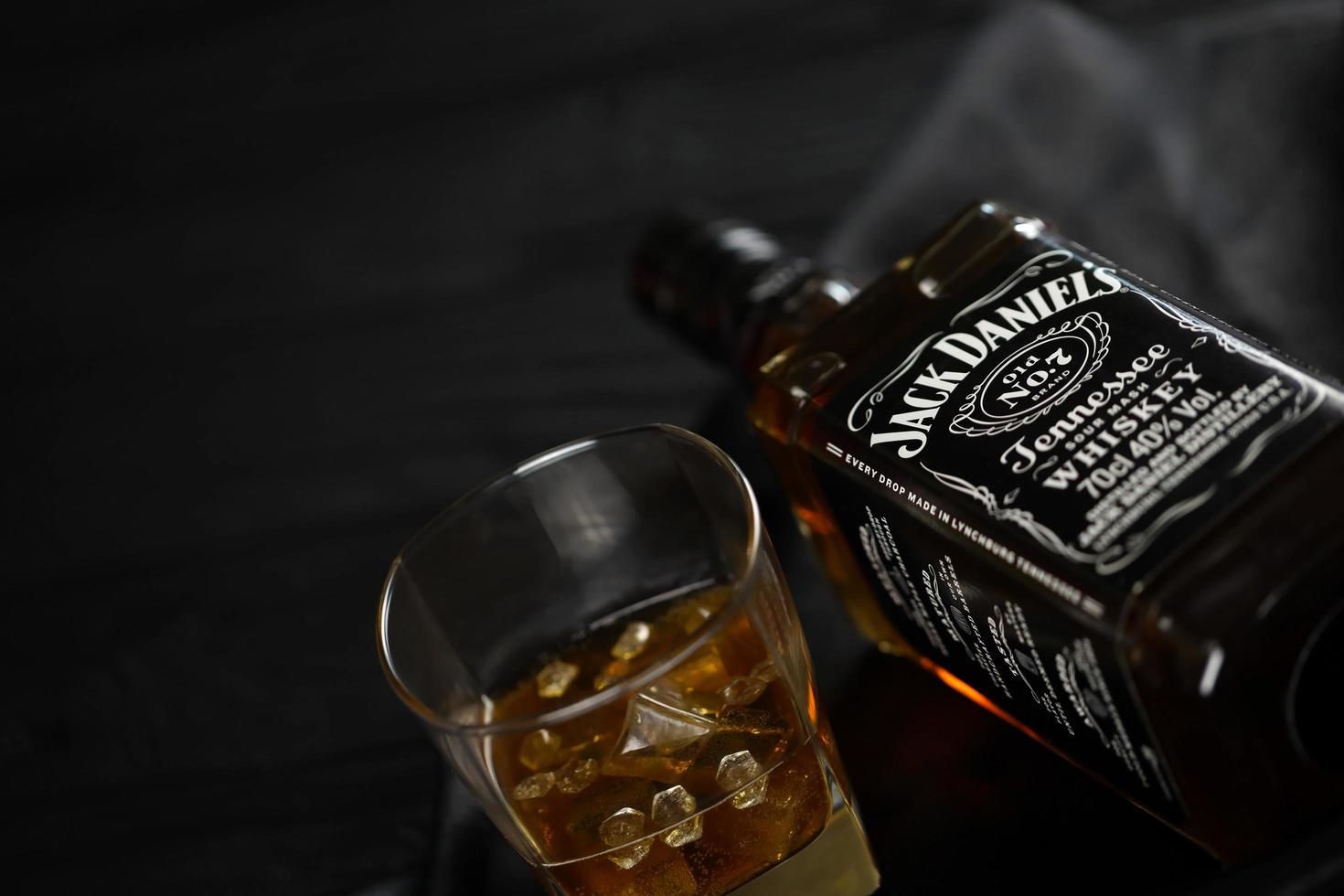 KYIV, UKRAINE - MAY 4, 2022 Jack Daniels original alcohol bottle on wooden table with black fabric photo