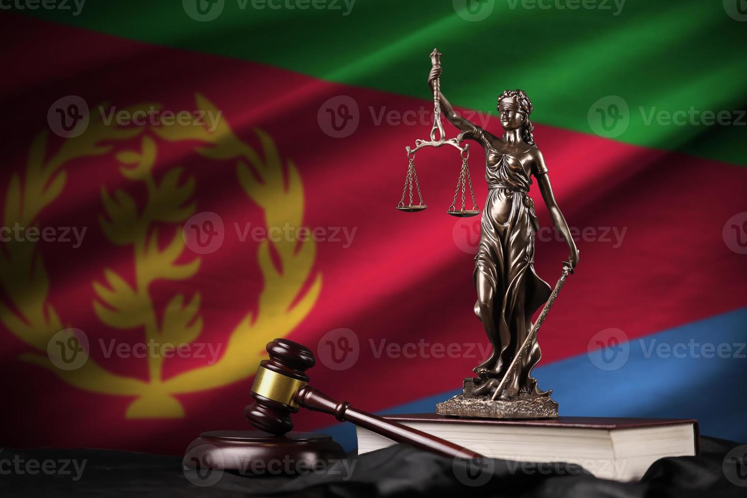 Eritrea flag with statue of lady justice, constitution and judge hammer on black drapery. Concept of judgement and guilt photo